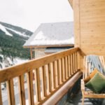 Luxury Lodgings - Brown Wooden Chair On A Veranda With View Of A Snowy Mountain